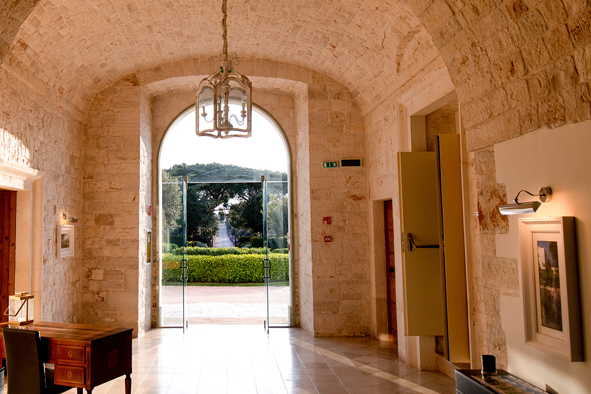 Ingresso del ristorante Il Santissimo a Turi con volte in pietra, porta ad arco e vista sul giardino.