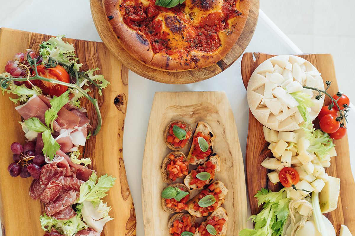 Taglieri gourmet con focaccia pugliese, bruschette al pomodoro, salumi e formaggi.