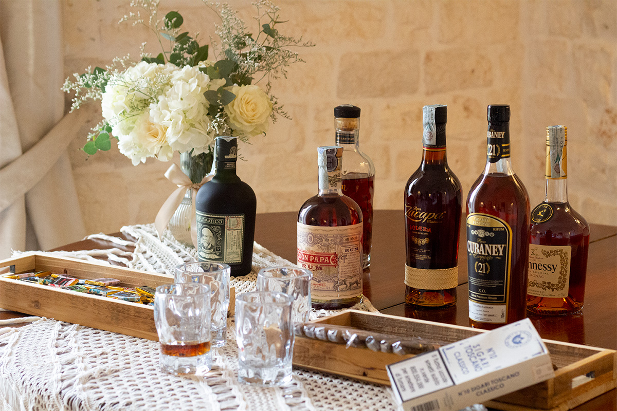 Angolo degustazione con rum, cognac, bicchieri e sigari.