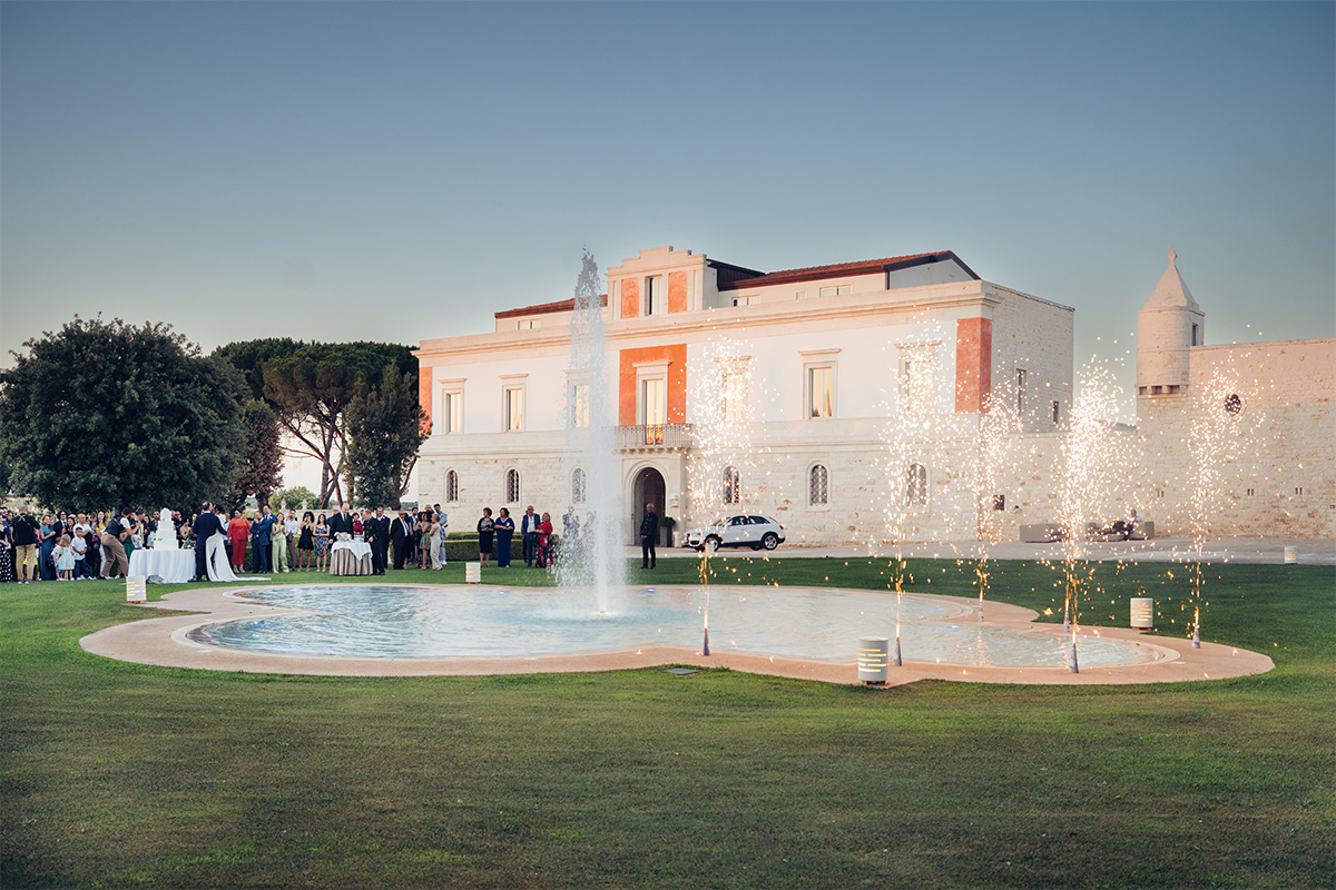 Vista esterna del palazzo storico con ospiti durante un evento all’aperto.
