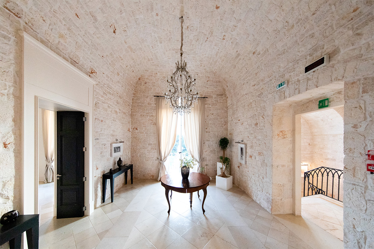 Disimpegno in pietra con lampadario e arredi d’epoca.