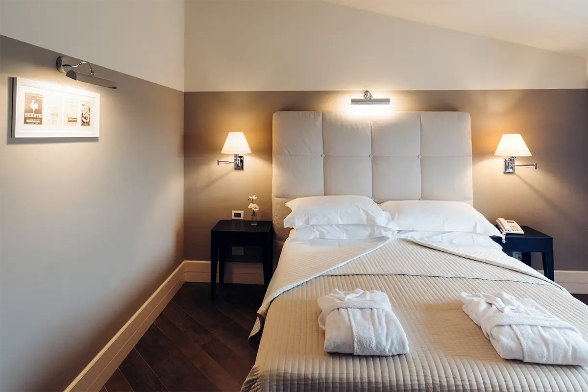 Camera con letto matrimoniale e luci da comodino.