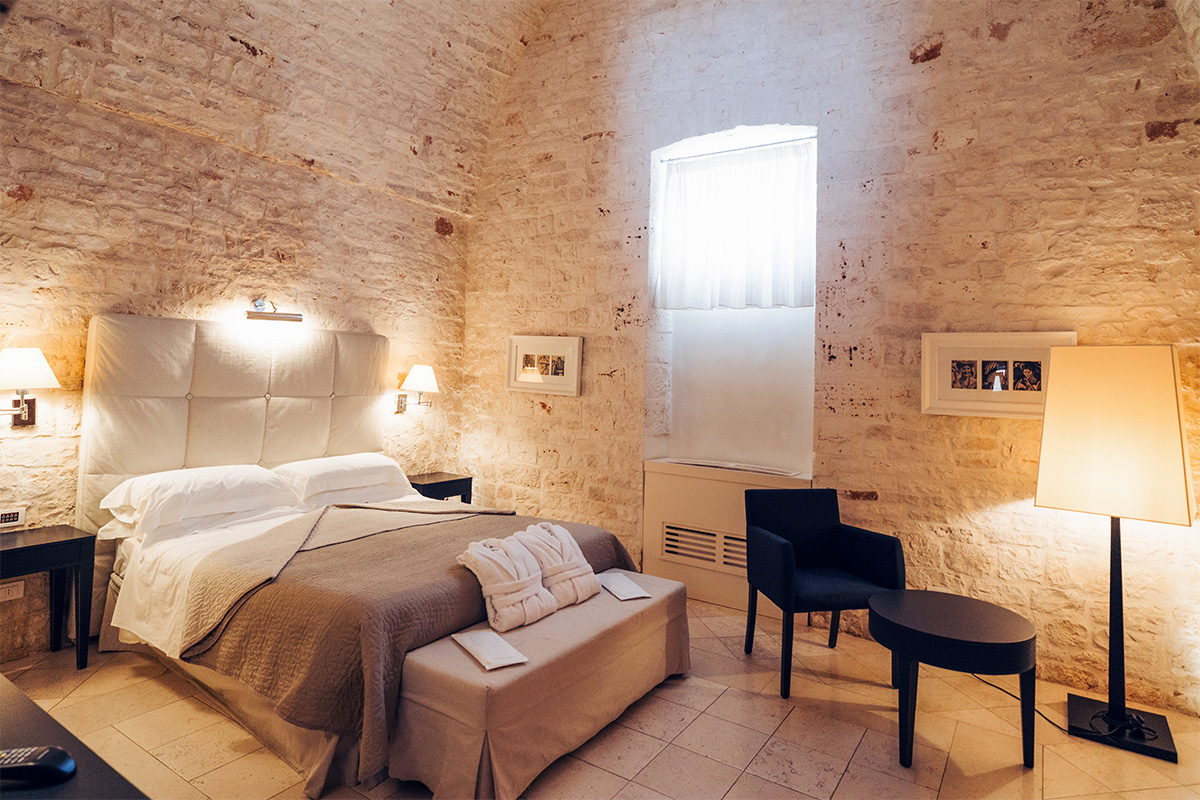 Suite del Massaro, a suite at hotel Relais Il Santissimo with stone vaults and ancient furnishings.