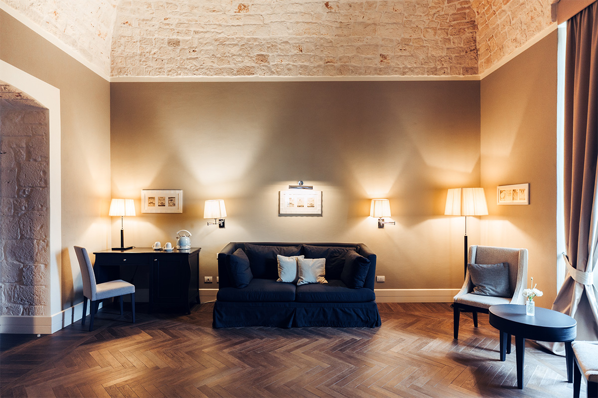Suite Padronale living room with sofa, blue walls and elegant furnishings.