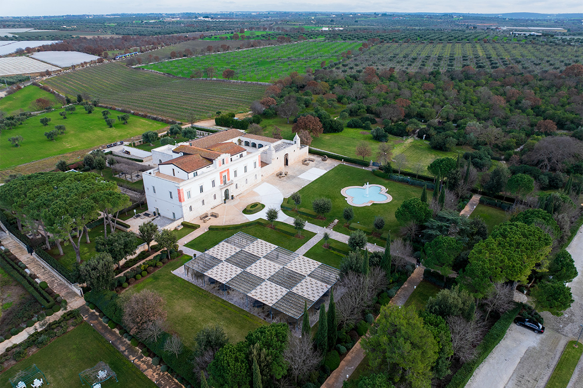 Aerial view of Relais Il Santissimo in Turi, with its historic building, farmhouse, park, gardens, and surrounding Apulian countryside.