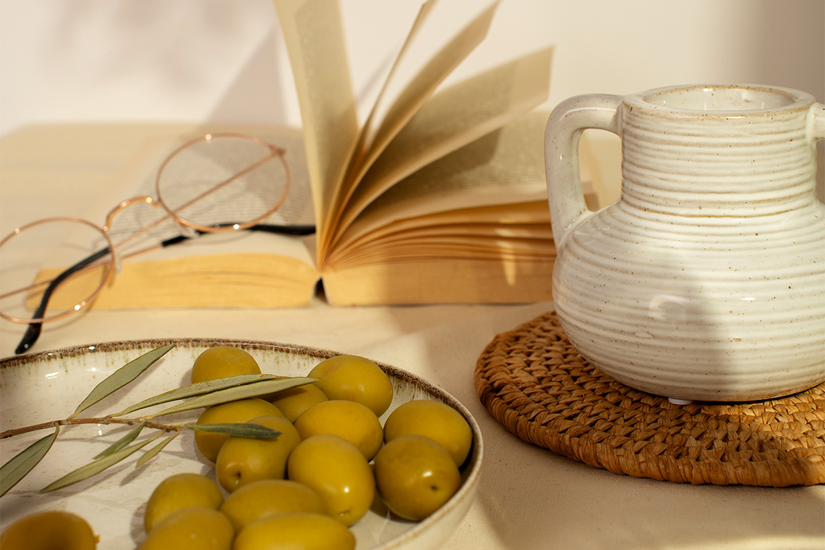 Green olives, a book, and a jug for sensory weddings at Il Santissimo inspired by Mediterranean flavors.