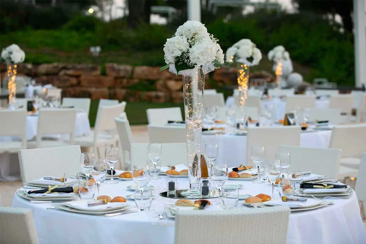 Elegant outdoor wedding table setting at Il Santissimo with white floral centerpieces.