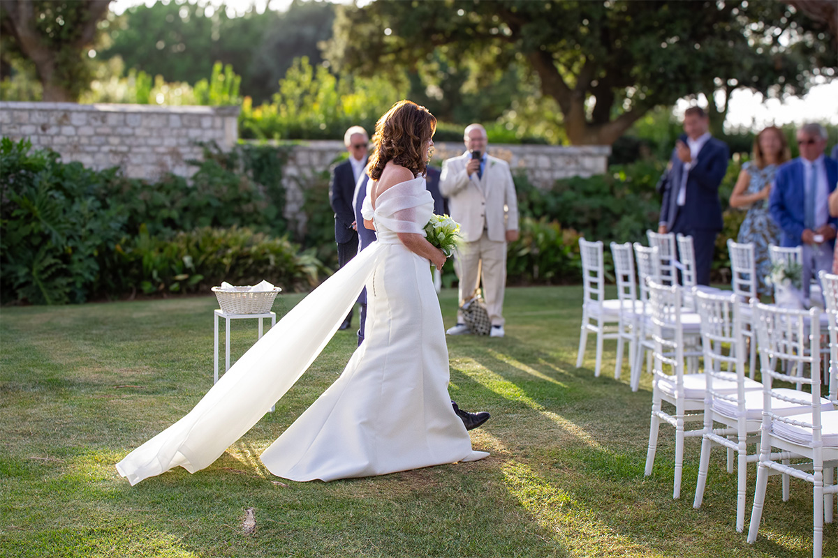 Bride walking down the outdoor aisle at Il Santissimo, venue for a romantic wedding in Puglia.