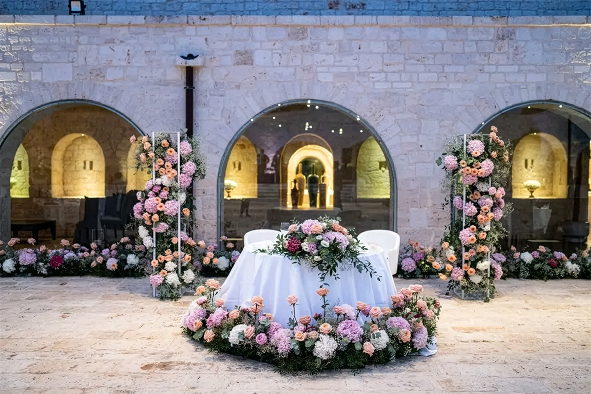 Floral wedding setup with decorated table and arches in the courtyard.