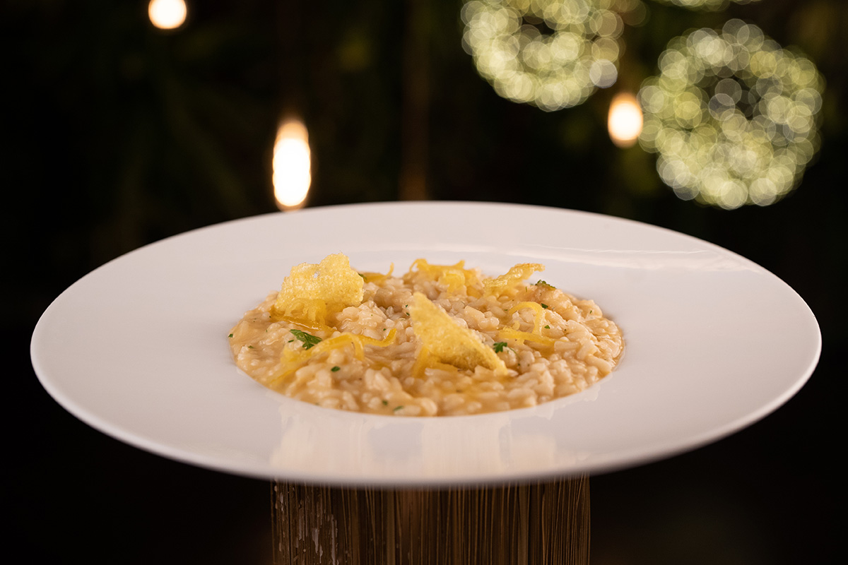 Risotto gourmet servito su piatto bianco.