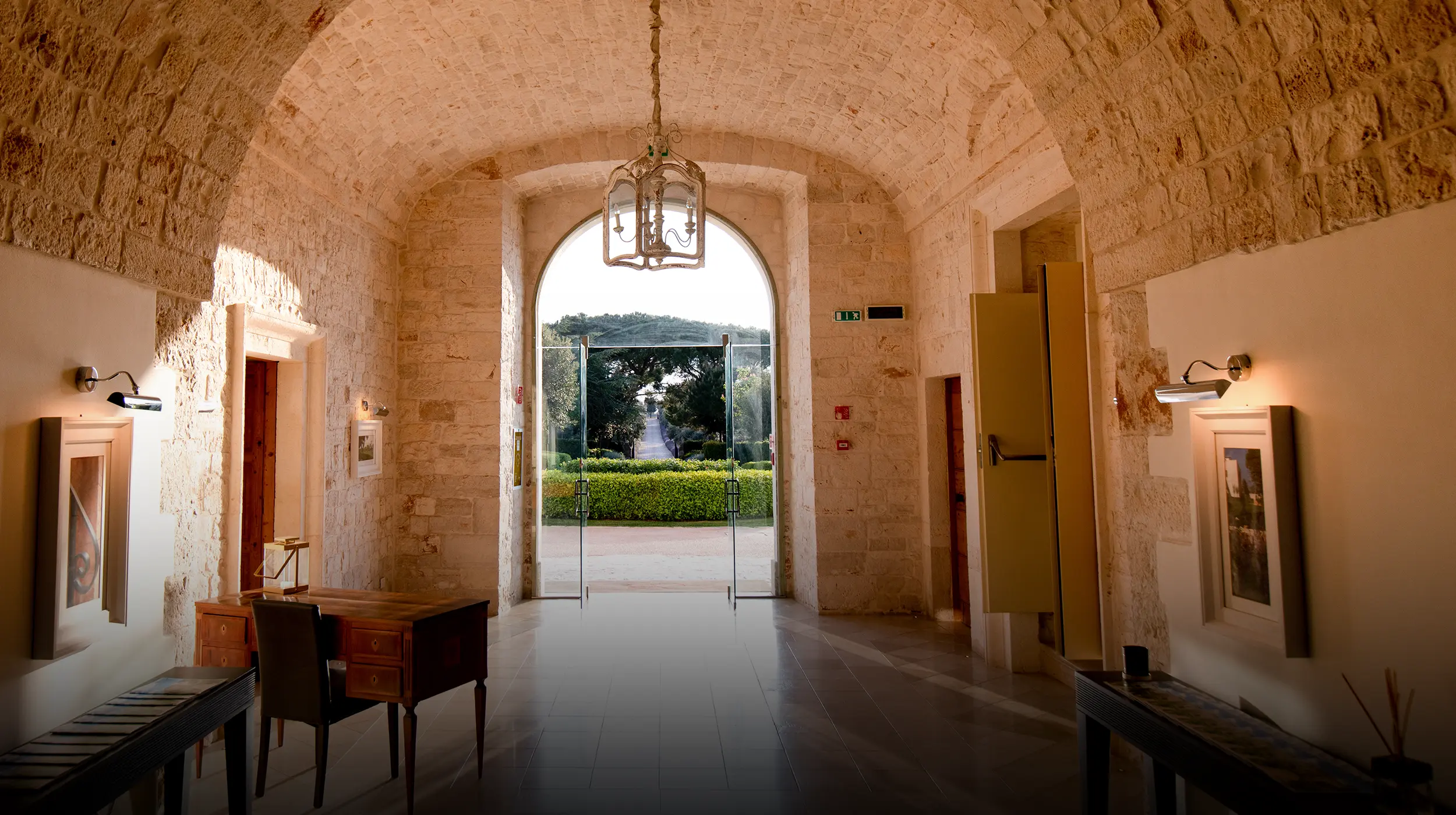 Ingresso in pietra del ristorante Il Santissimo a Turi con volta ad arco e vista sul giardino.